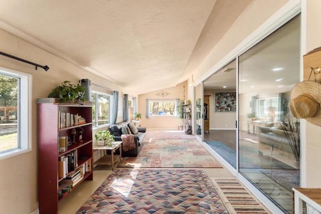 interior space with baseboards, a textured ceiling, and vaulted ceiling