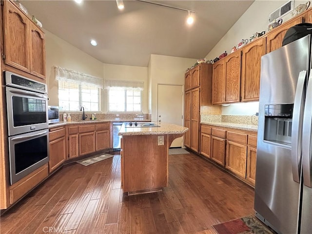kitchen featuring light countertops, a sink, lofted ceiling, and stainless steel appliances