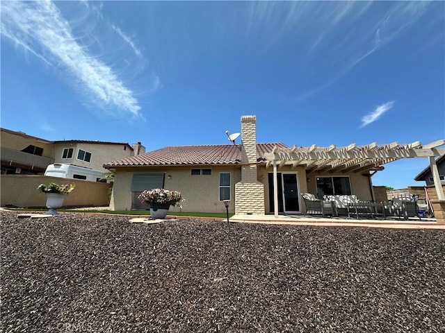 back of house featuring fence, a pergola, a tile roof, stucco siding, and a chimney