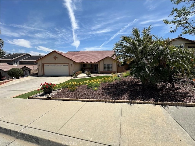 single story home featuring an attached garage, stucco siding, a tile roof, and concrete driveway