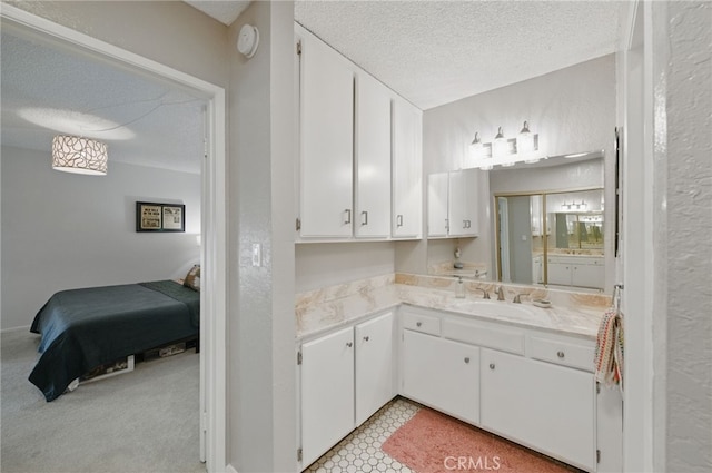 ensuite bathroom with vanity, a textured ceiling, and connected bathroom