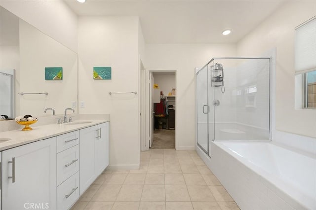 bathroom featuring tile patterned flooring, double vanity, a walk in closet, a shower stall, and a sink