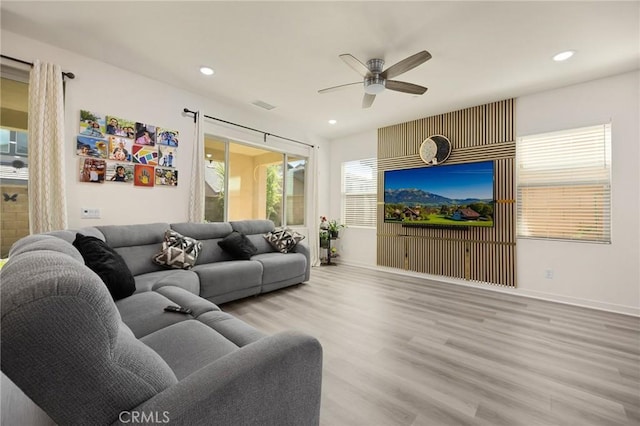 living room featuring ceiling fan, visible vents, wood finished floors, baseboards, and recessed lighting