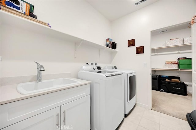 clothes washing area featuring visible vents, light colored carpet, separate washer and dryer, a sink, and light tile patterned floors