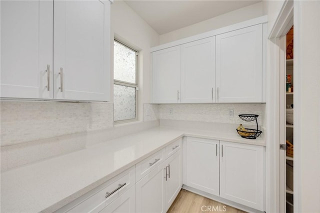 kitchen with light countertops, decorative backsplash, and white cabinetry