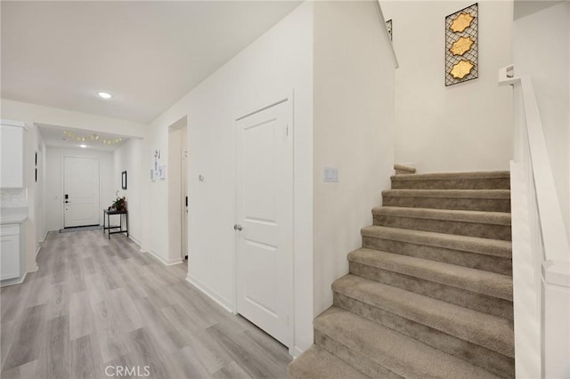 staircase with recessed lighting, baseboards, and wood finished floors