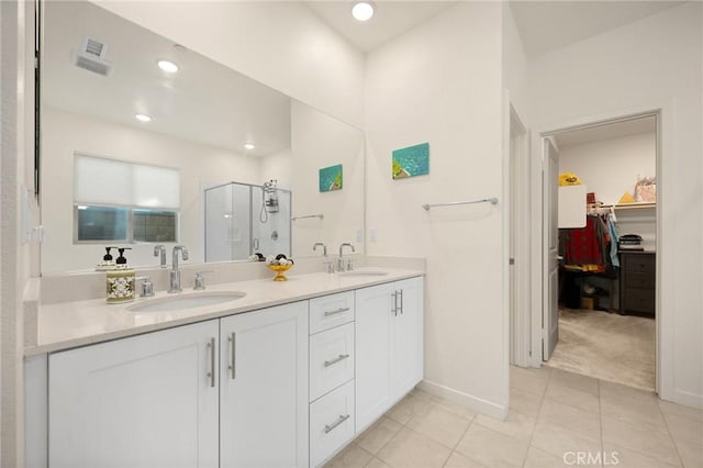 full bath featuring double vanity, tile patterned floors, a sink, and a stall shower