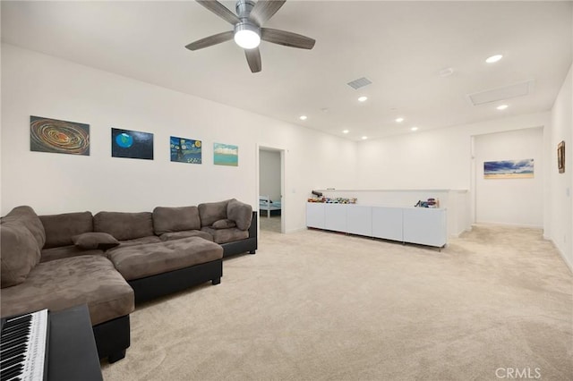 living area with a ceiling fan, attic access, visible vents, light colored carpet, and recessed lighting