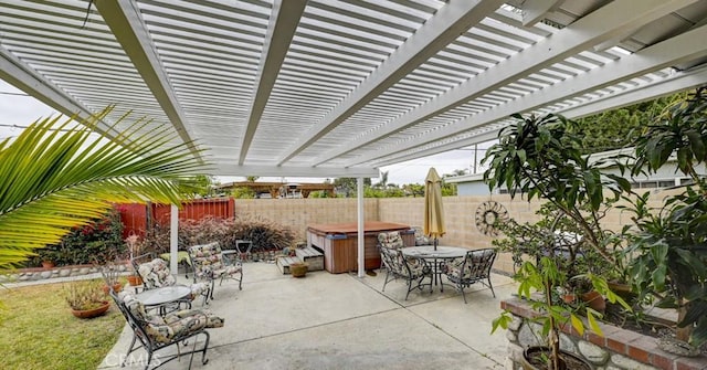 view of patio with a hot tub, a pergola, a fenced backyard, and outdoor dining space