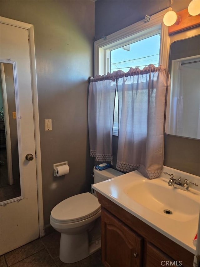 bathroom featuring vanity, tile patterned floors, and toilet