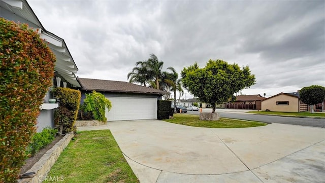 view of home's exterior with a garage, a yard, and driveway