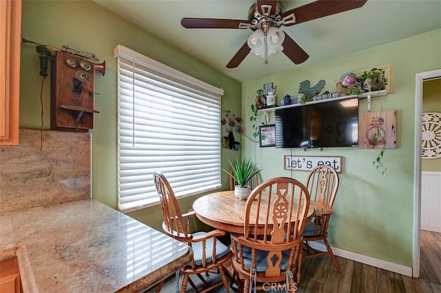 dining room with baseboards, a ceiling fan, wood finished floors, and a wealth of natural light