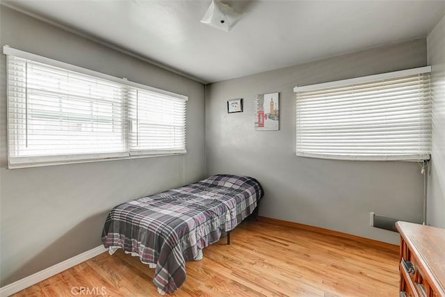 bedroom with baseboards and wood finished floors