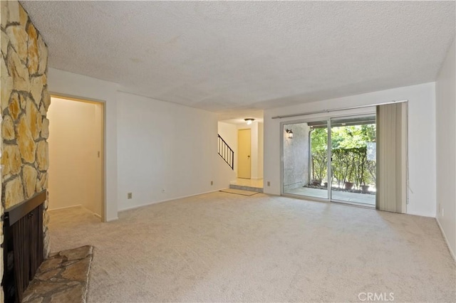 9502 Via Salerno, Burbank, CA 91504 - unfurnished living room featuring a textured ceiling, carpet floors, a fireplace, and stairs