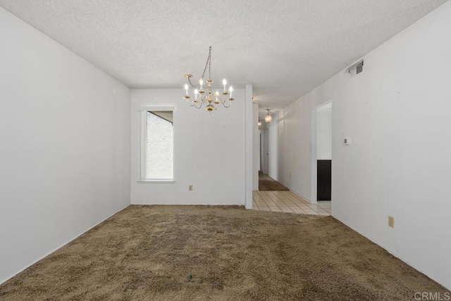 unfurnished room featuring a textured ceiling, a notable chandelier, and light carpet