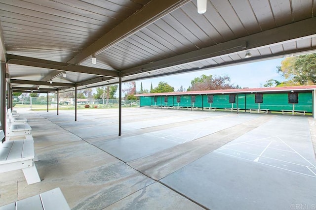 view of community with shuffleboard and fence