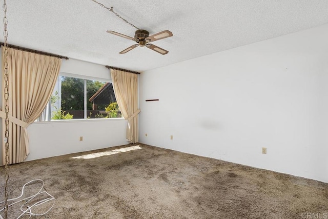 empty room featuring carpet floors, a ceiling fan, and a textured ceiling