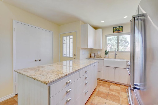 1982 Fairlee Dr, Encinitas, CA 92024 - kitchen with freestanding refrigerator, a sink, light stone countertops, white cabinetry, and recessed lighting