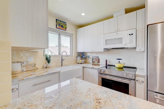 1982 Fairlee Dr, Encinitas, CA 92024 - kitchen featuring appliances with stainless steel finishes, light stone counters, decorative backsplash, recessed lighting, and white cabinetry