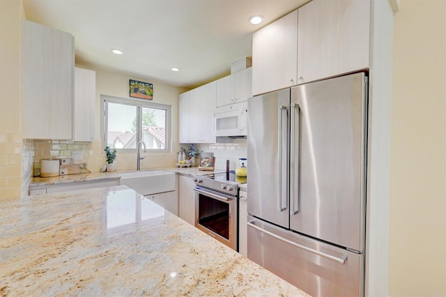 1982 Fairlee Dr, Encinitas, CA 92024 - kitchen with appliances with stainless steel finishes, backsplash, light stone countertops, recessed lighting, and white cabinets