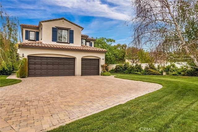 view of front of house featuring a garage, decorative driveway, stucco siding, and a front yard