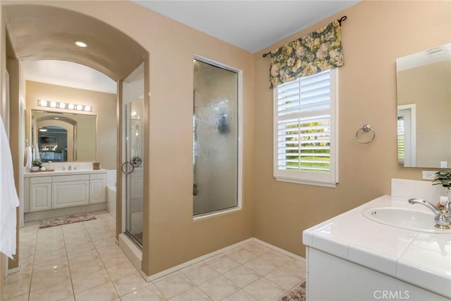 bathroom featuring a sink, tile patterned floors, baseboards, visible vents, and a stall shower