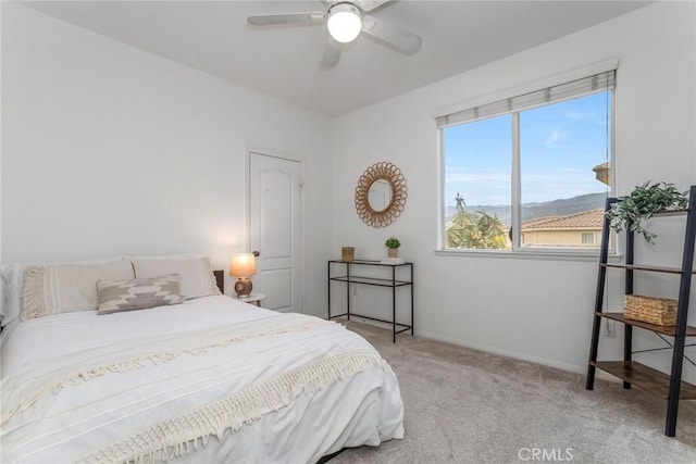 bedroom with baseboards, ceiling fan, and light carpet
