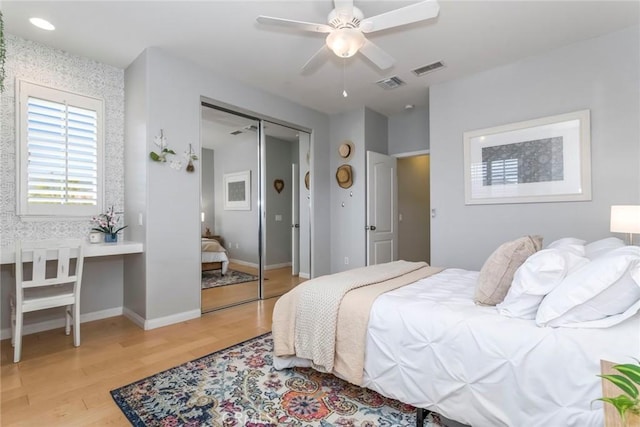 bedroom with visible vents, light wood-style flooring, baseboards, and a closet