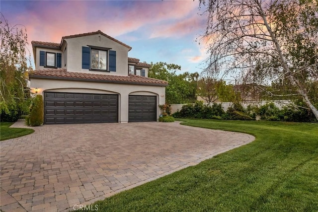 exterior space featuring decorative driveway, a garage, stucco siding, and a front yard
