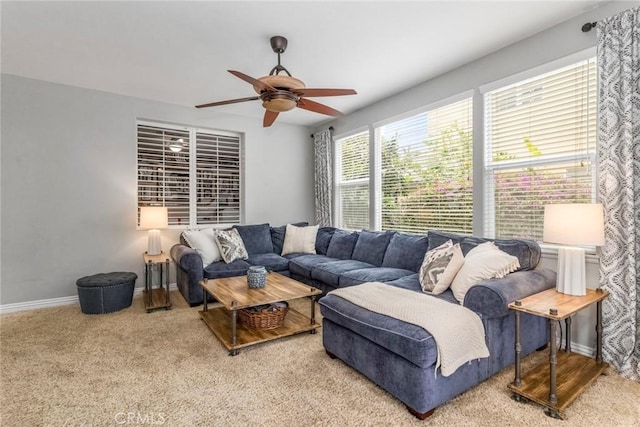 carpeted living room featuring baseboards and a ceiling fan