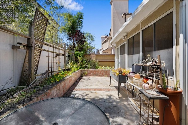 view of patio with a fenced backyard and a sunroom