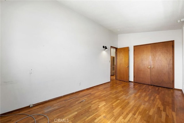 unfurnished bedroom with a closet and light wood-type flooring
