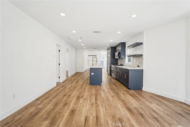 3427 S Victoria Ave, Los Angeles, CA 90016 - kitchen featuring open shelves, light countertops, light wood-style flooring, stainless steel appliances, and visible vents