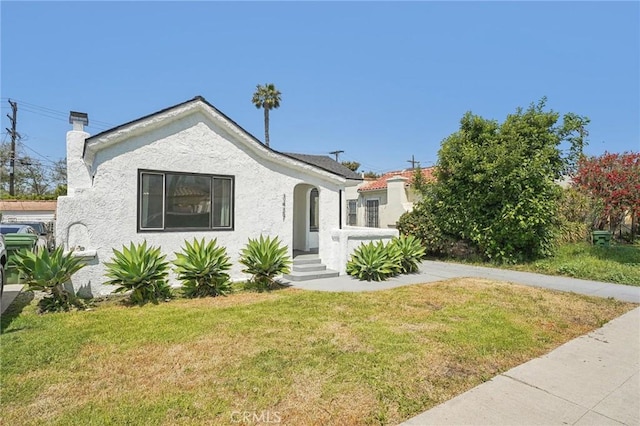 3427 S Victoria Ave, Los Angeles, CA 90016 - view of front of house with a front lawn, stucco siding, and a chimney