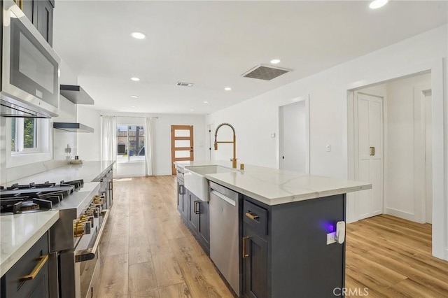 3427 S Victoria Ave, Los Angeles, CA 90016 - kitchen with open shelves, appliances with stainless steel finishes, a sink, and light wood-type flooring