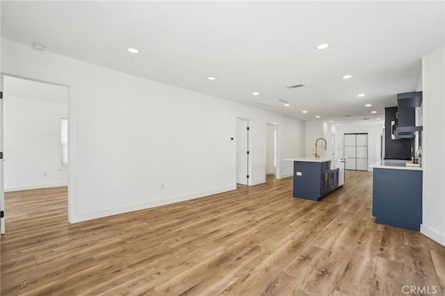 3427 S Victoria Ave, Los Angeles, CA 90016 - unfurnished living room featuring recessed lighting, a sink, light wood-style flooring, and baseboards