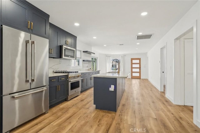 3427 S Victoria Ave, Los Angeles, CA 90016 - kitchen with visible vents, a sink, light countertops, light wood finished floors, and premium appliances