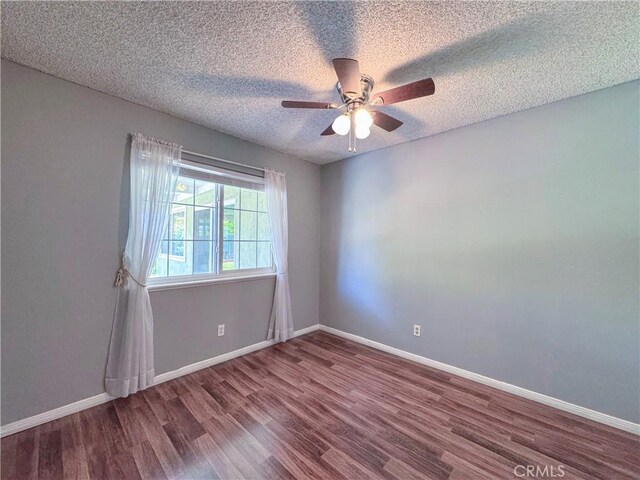 unfurnished room featuring baseboards, a ceiling fan, a textured ceiling, and wood finished floors