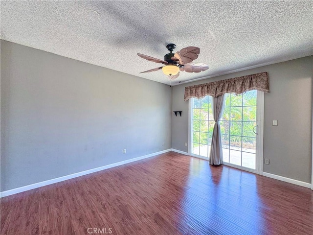 empty room with baseboards, a ceiling fan, a textured ceiling, and wood finished floors