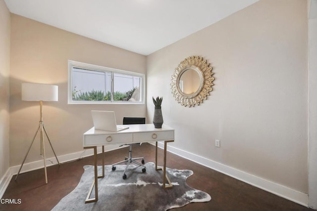 office space featuring baseboards and concrete floors