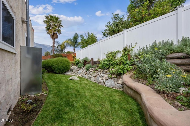 view of yard featuring a fenced backyard and a mountain view