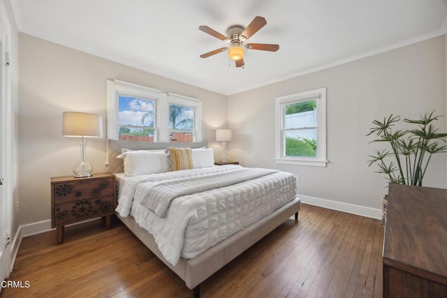 bedroom featuring crown molding, baseboards, wood-type flooring, and a ceiling fan
