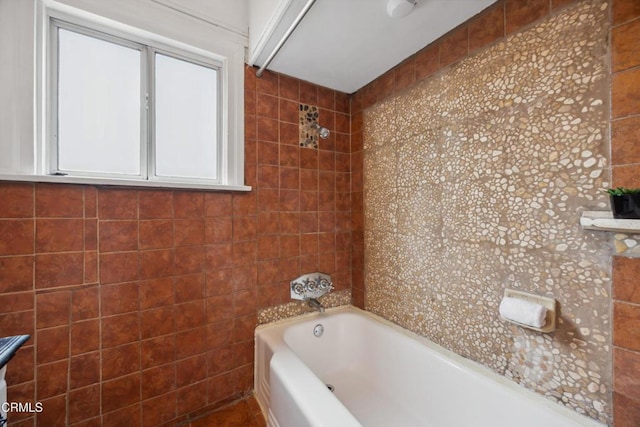 full bathroom featuring shower / bath combination and tile walls