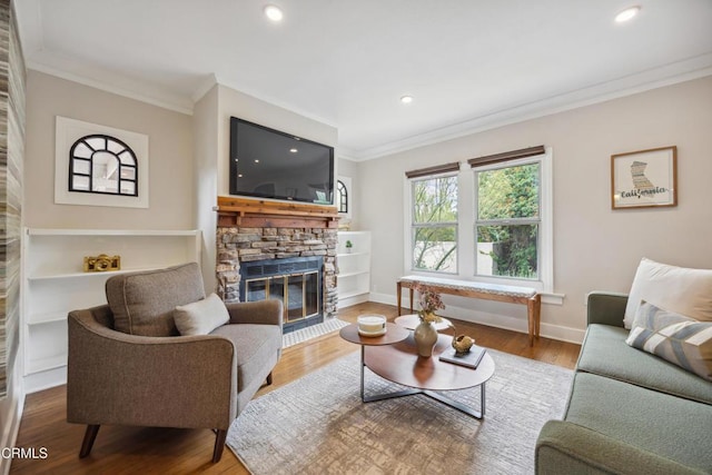living area featuring crown molding, a fireplace, recessed lighting, and wood finished floors