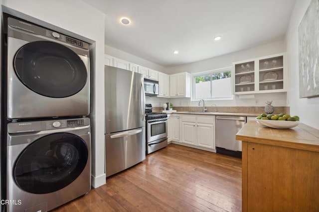 kitchen featuring stacked washer / dryer, open shelves, white cabinets, stainless steel appliances, and dark wood-type flooring