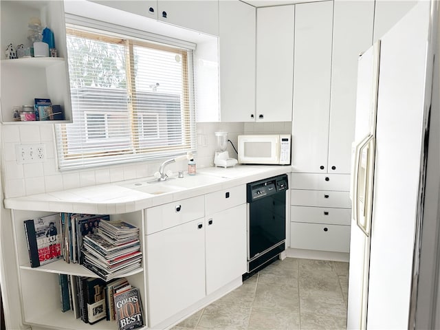 kitchen featuring open shelves, black dishwasher, white microwave, white cabinetry, and a sink