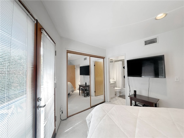 bedroom featuring visible vents, light carpet, and french doors