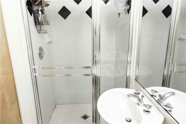 full bathroom featuring a shower stall and a sink