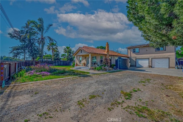 2415 E Childs Ave, Merced, CA 95341 - view of front facade featuring roof mounted solar panels, fence, driveway, and a garage