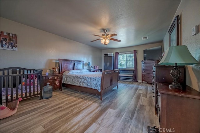 2415 E Childs Ave, Merced, CA 95341 - bedroom with visible vents, light wood-style floors, baseboards, ceiling fan, and a textured ceiling